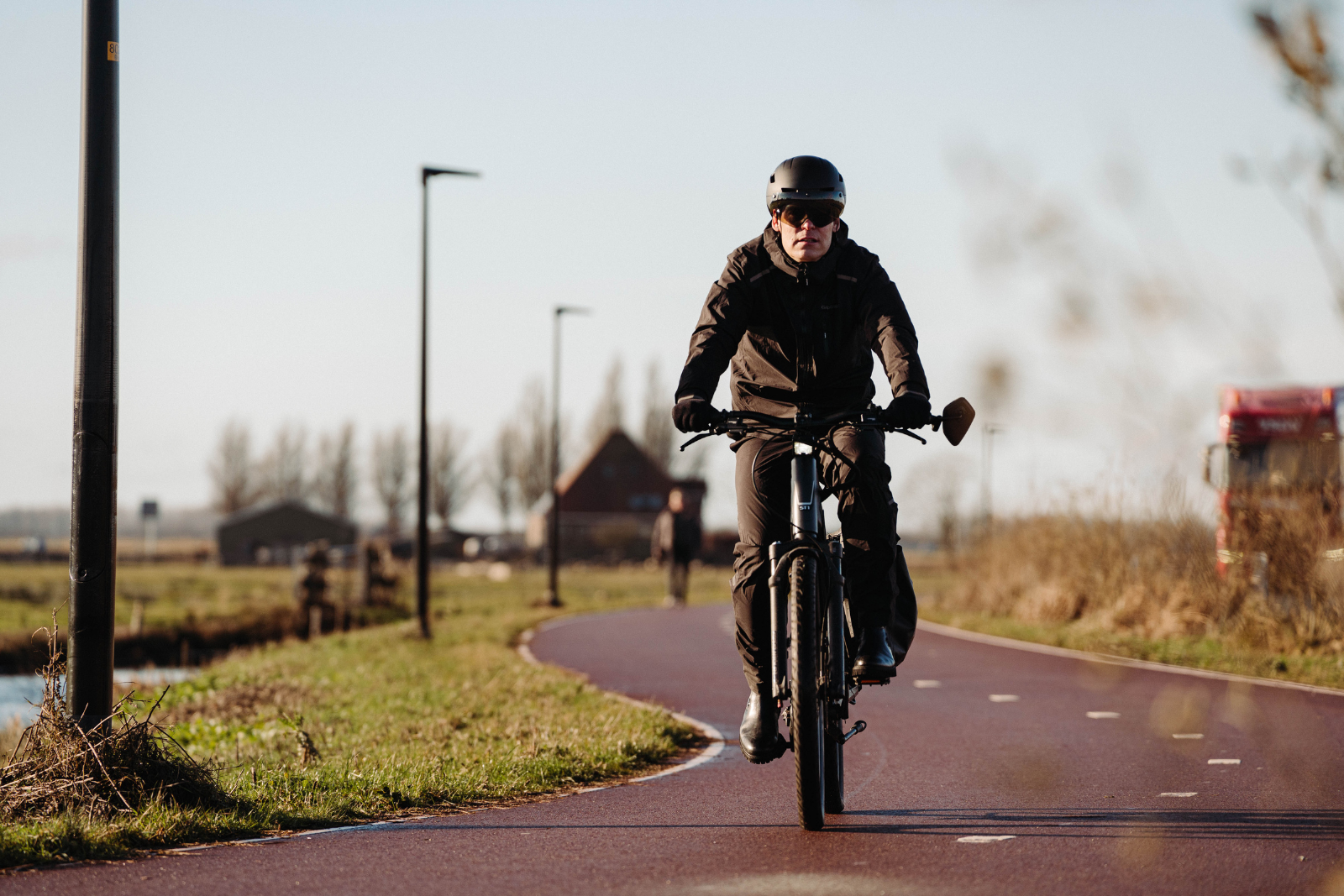 Fietser draagt de zwarte GripGrab EXPLR regenjas en regenbroek tijdens een fietstocht.