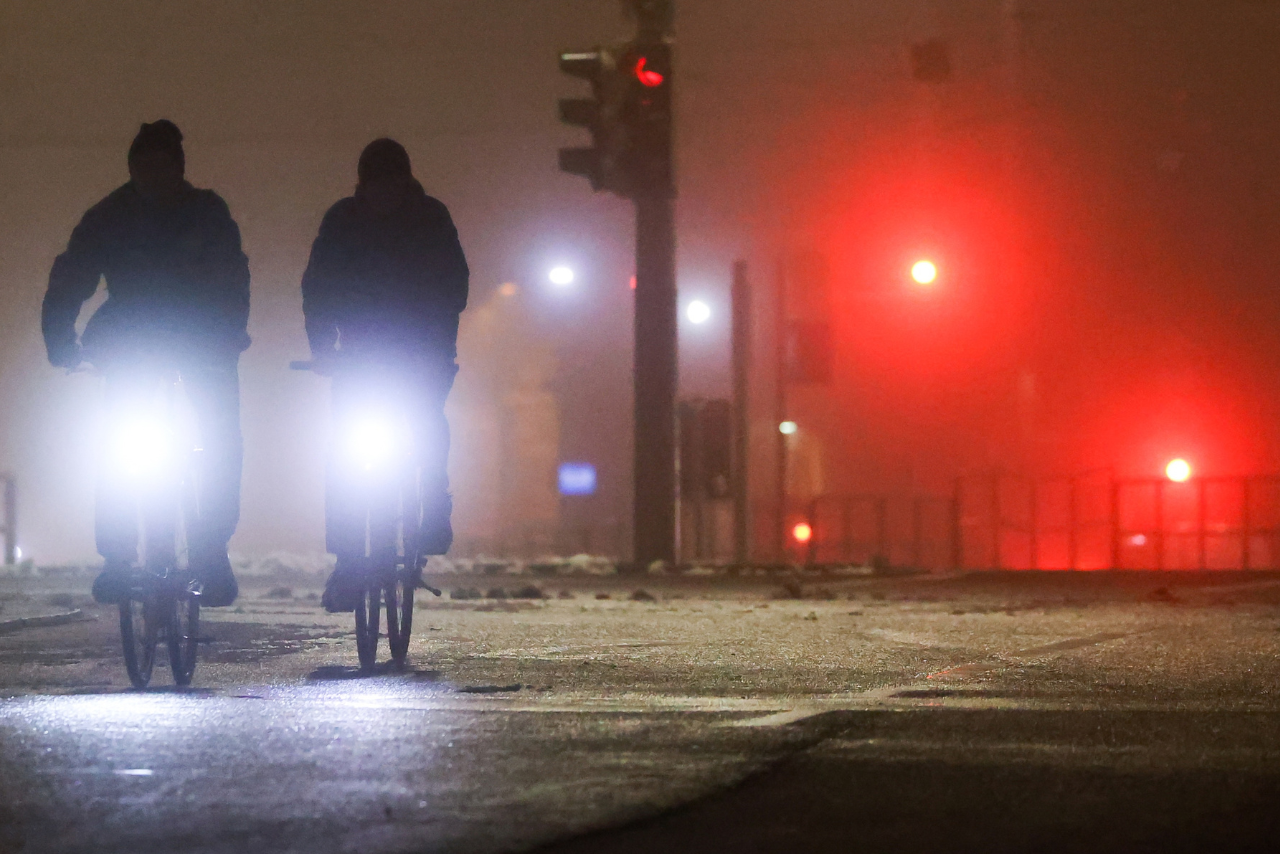 Twee fietsers rijden in het donker met heldere voorlichten aan.