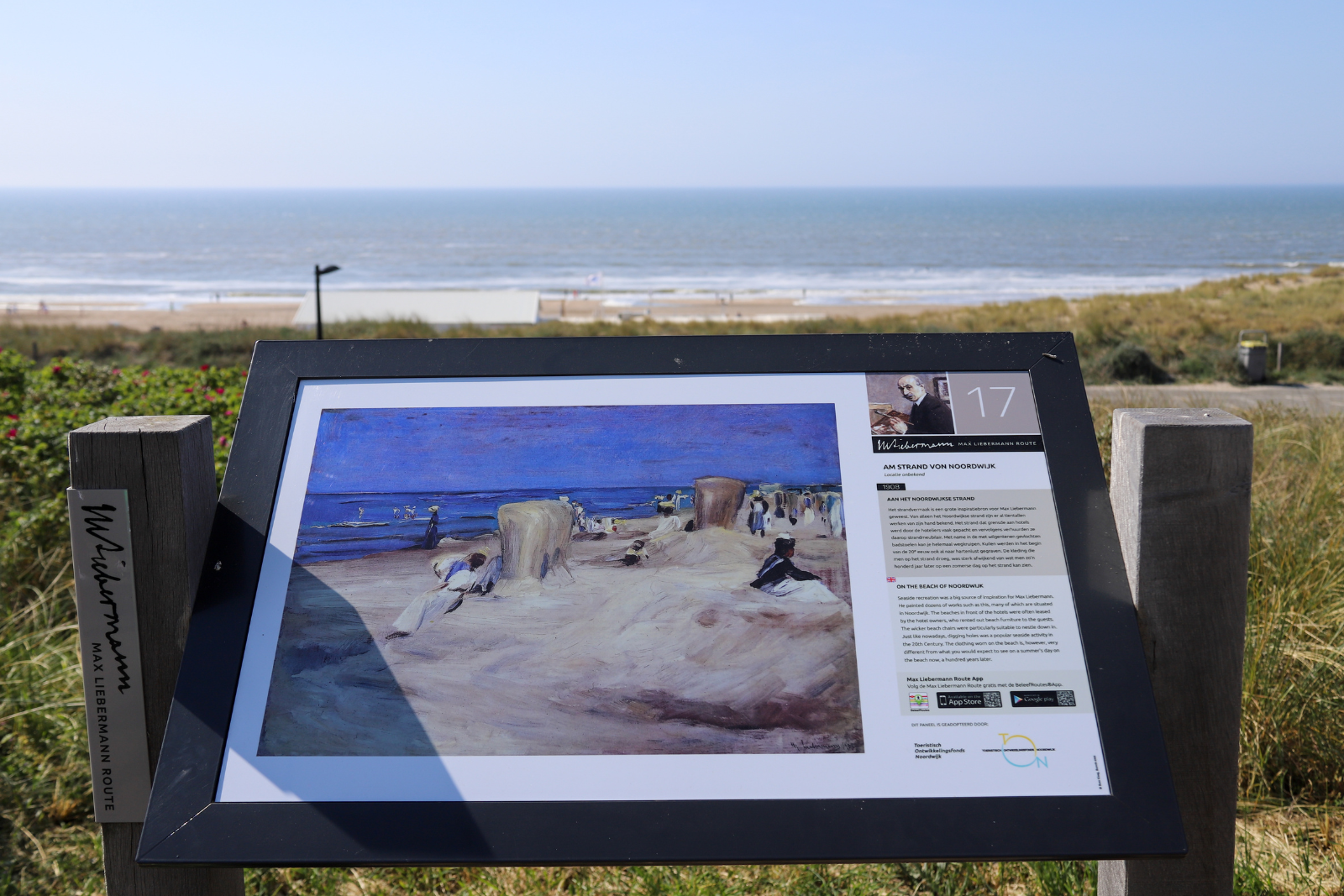 Informatiebord van de Max Liebermann Route aan het strand van Noordwijk, met een schilderij van de kust.