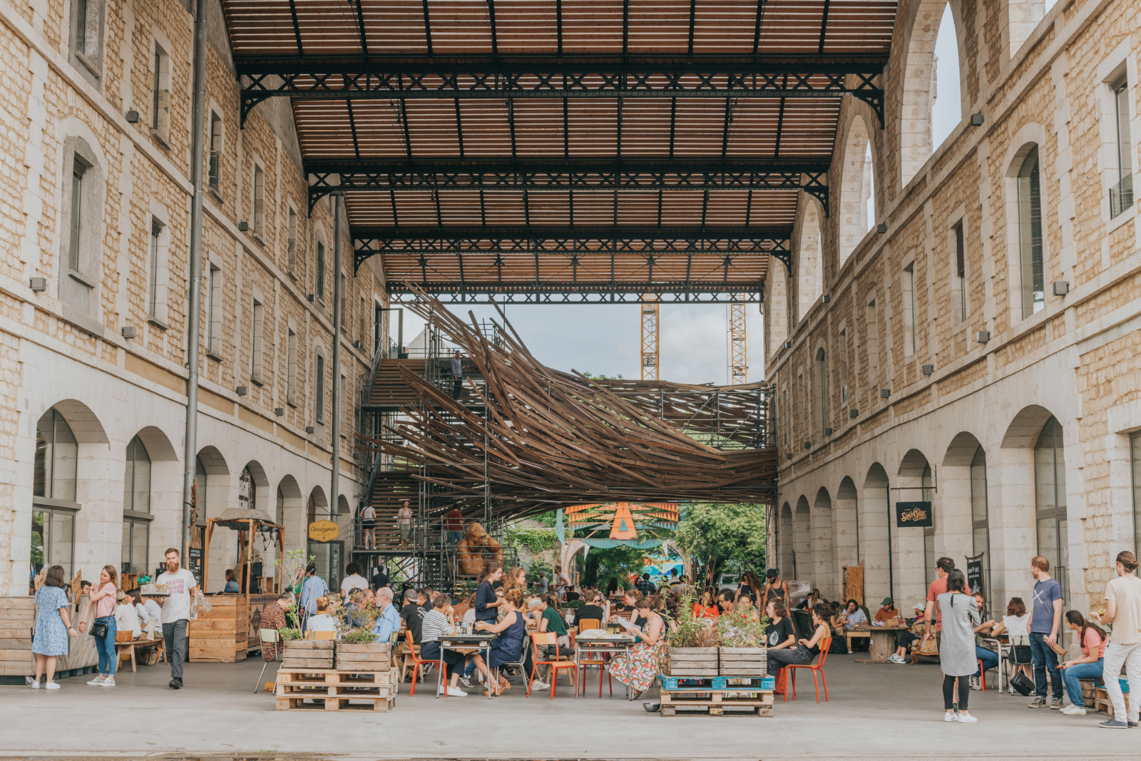 Bezoekers zitten op het terras van Darwin Écosystème in Bordeaux, gevestigd in een voormalige kazerne.