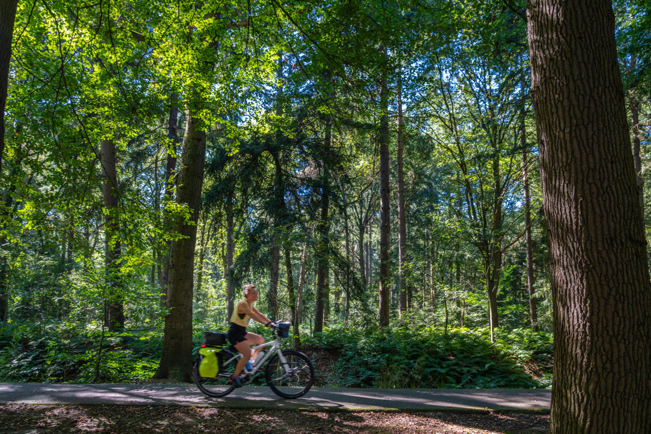 Vrouw fietst langs de Oostopgaande bij Hoogeveen, een historische hoofdvaart uit de tijd van de turfwinning.
