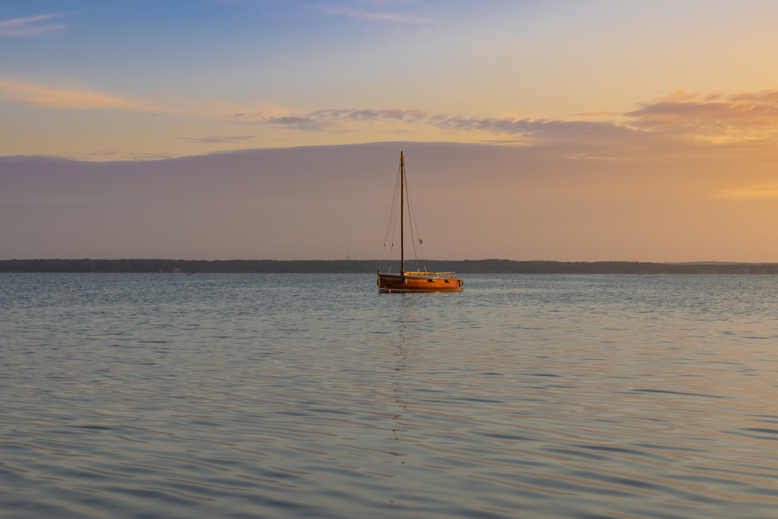 Zeilboot op het Steinhuder Meer tijdens zonsondergang, met warm avondlicht boven het water.